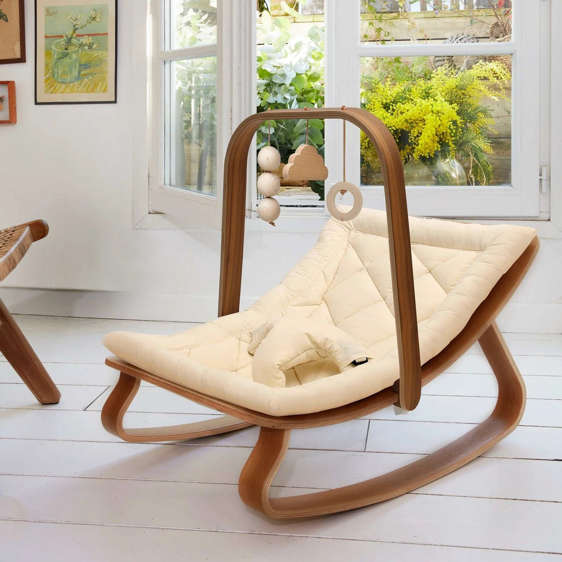 Moderne Babywippe aus Holz mit gepolsterter Liegefläche und Spieltrapez